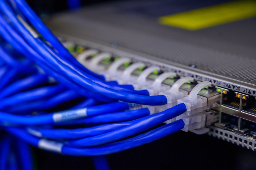 Anasayfa Detailed view of blue ethernet cables connected to a network switch in a data center.